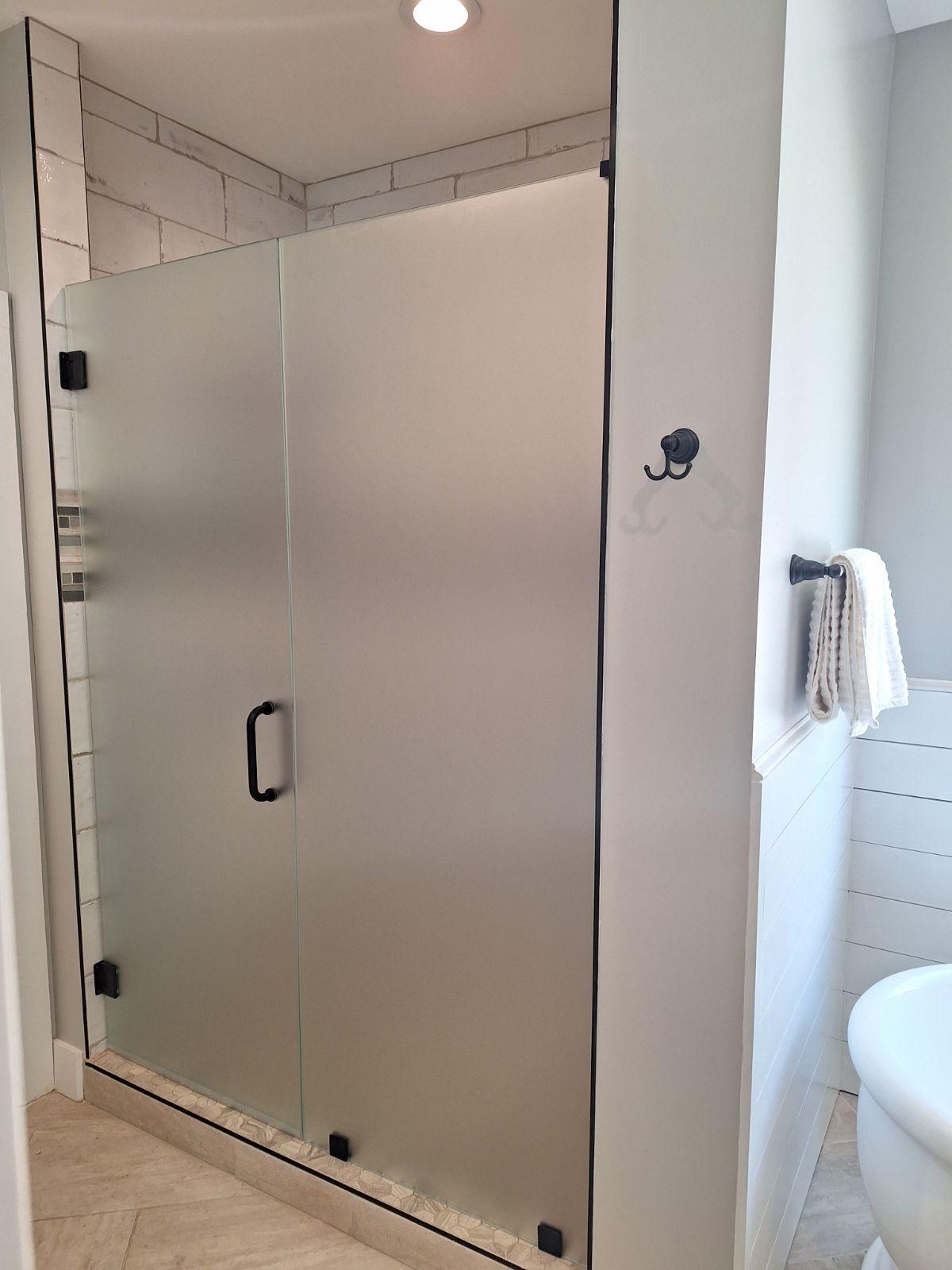 Frosted glass shower enclosure providing privacy while allowing natural light into the bathroom.