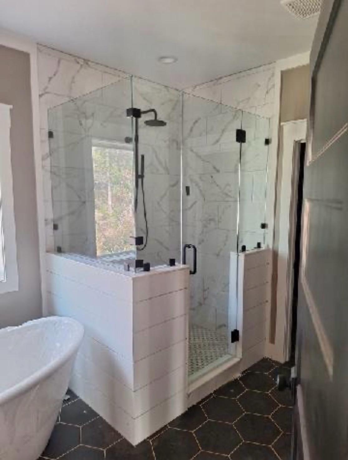 Custom corner frameless glass shower enclosure installed in a modern bathroom.