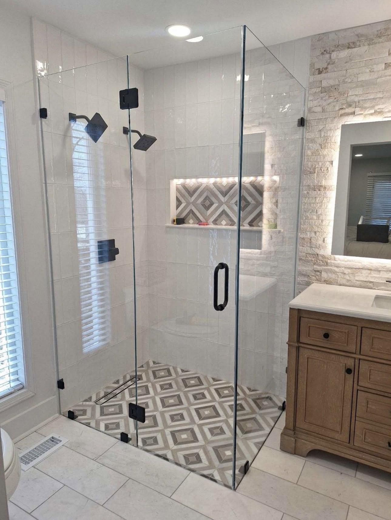 Custom frameless glass shower enclosure in a modern bathroom.
