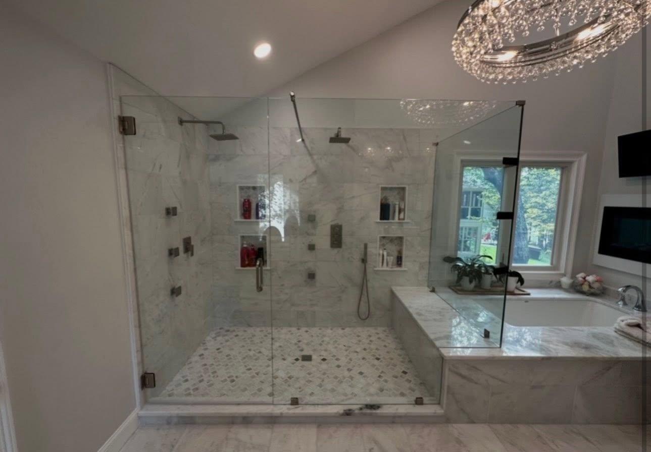 Professionally installed frameless glass shower door with polished hardware in a modern bathroom.